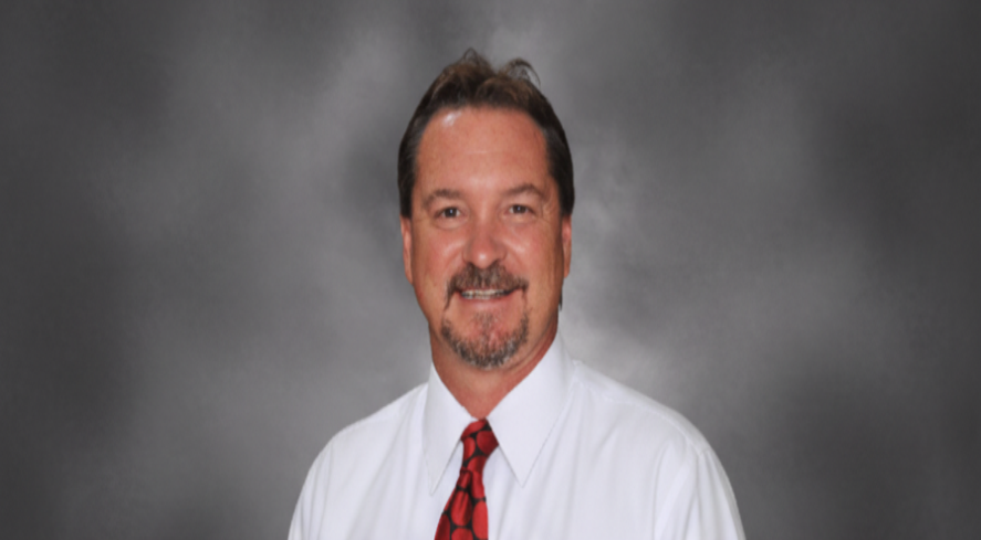 Man wearing a white shirt and red tie against a gray background